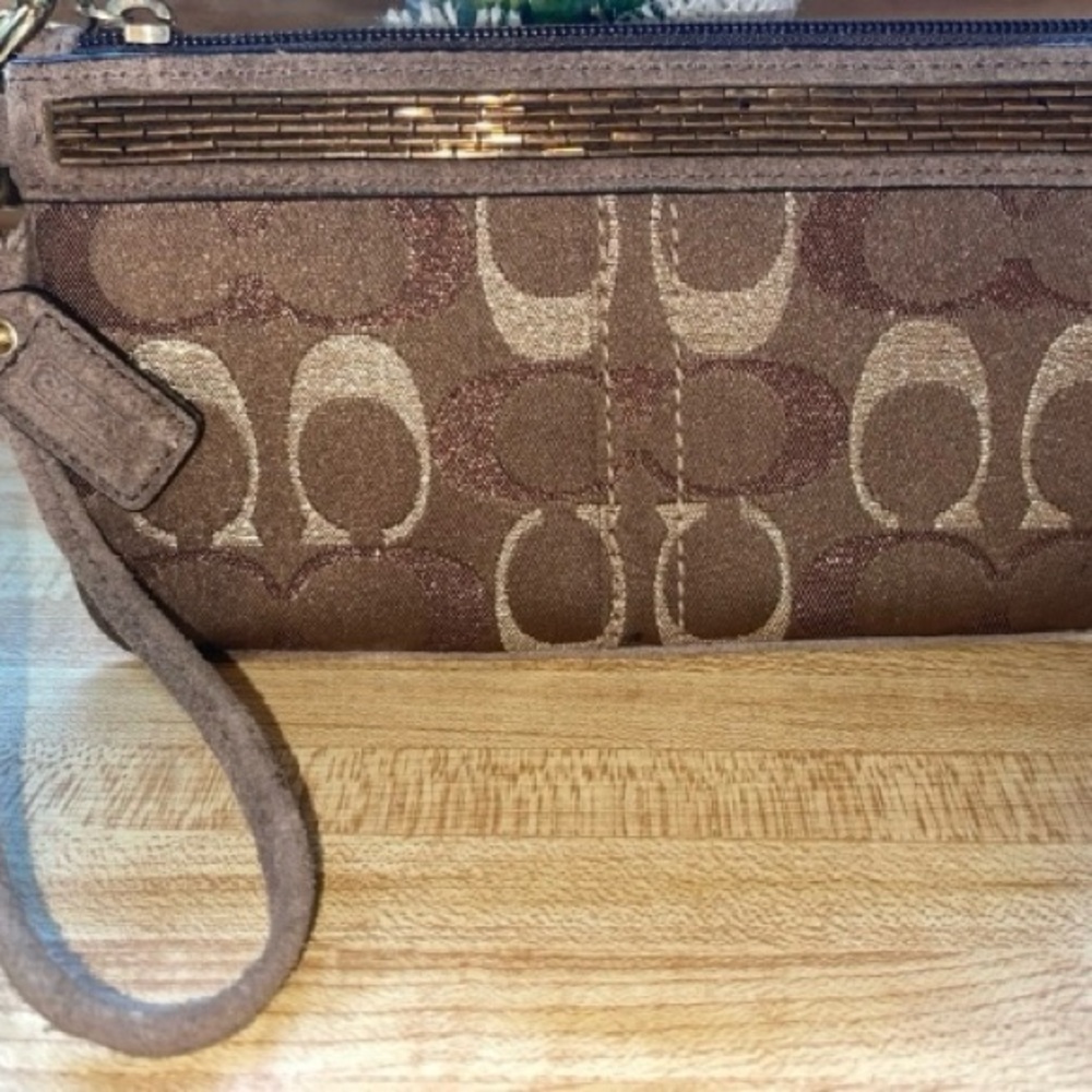 Coach Signature wristlet with beaded detail.